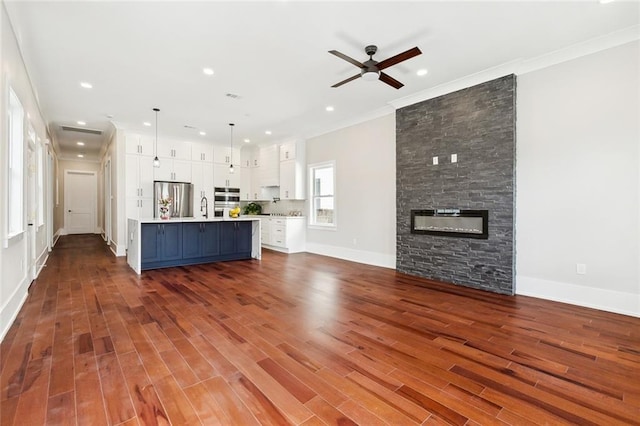 kitchen with an island with sink, ceiling fan, sink, dark wood-type flooring, and stainless steel dishwasher