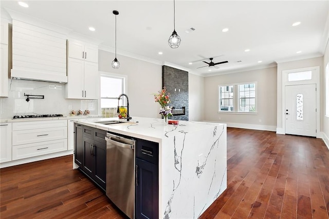 kitchen featuring appliances with stainless steel finishes, dark hardwood / wood-style flooring, a center island with sink, and hanging light fixtures