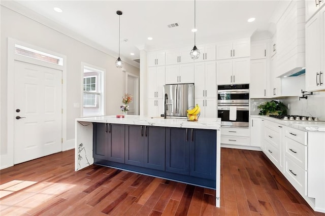 unfurnished room featuring a barn door, ceiling fan, hardwood / wood-style floors, and a tray ceiling