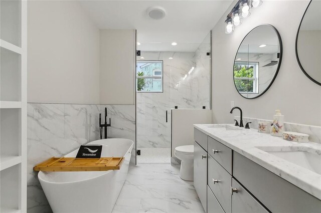 2634 St Ann St, New Orleans, LA 70119 - bathroom featuring marble finish flooring, a marble finish shower, double vanity, a soaking tub, and tile walls
