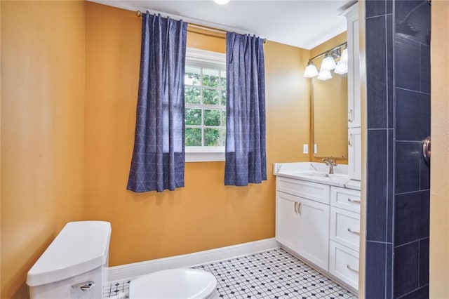 bathroom with toilet, vanity, and tile patterned flooring