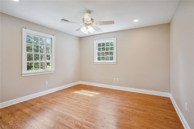 spare room featuring light hardwood / wood-style flooring, a healthy amount of sunlight, and ceiling fan