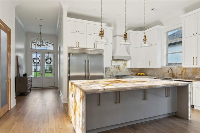 kitchen with hardwood / wood-style floors, appliances with stainless steel finishes, plenty of natural light, and a breakfast bar