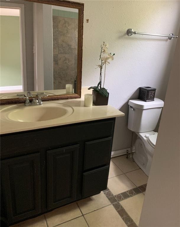 bathroom featuring vanity, tile patterned flooring, and toilet