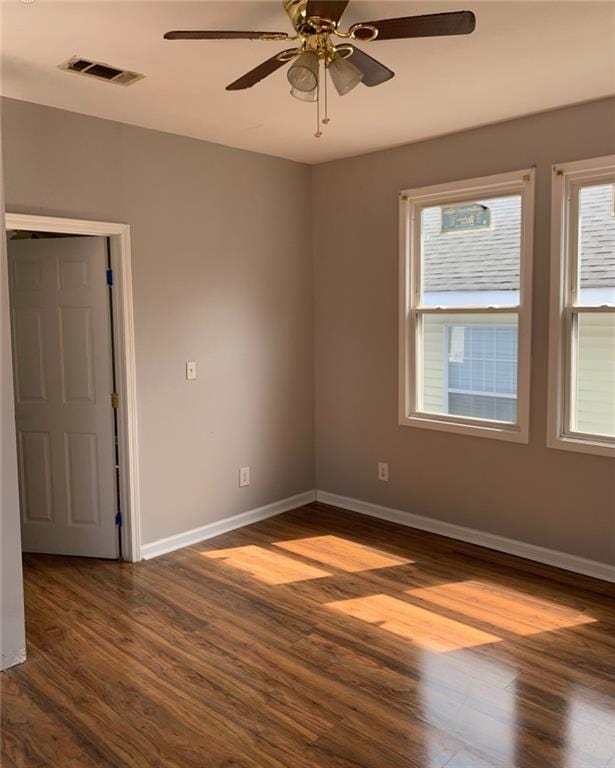 unfurnished room featuring ceiling fan and dark wood-type flooring