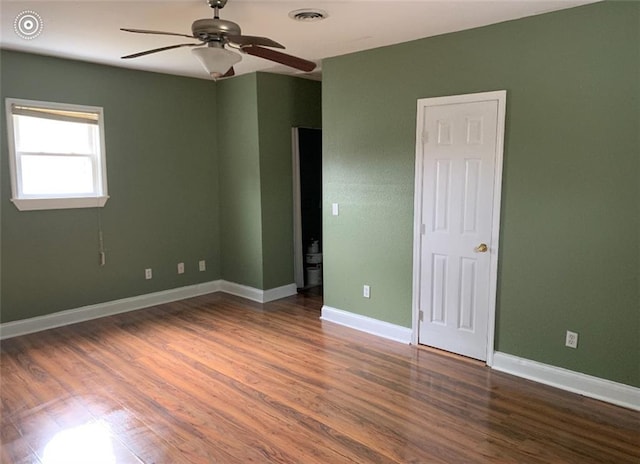 spare room with ceiling fan and dark hardwood / wood-style flooring