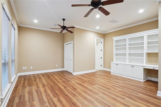 interior space featuring multiple windows, ornamental molding, ceiling fan, and light hardwood / wood-style flooring