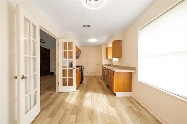 kitchen with dishwasher, range with gas stovetop, french doors, light hardwood / wood-style floors, and sink