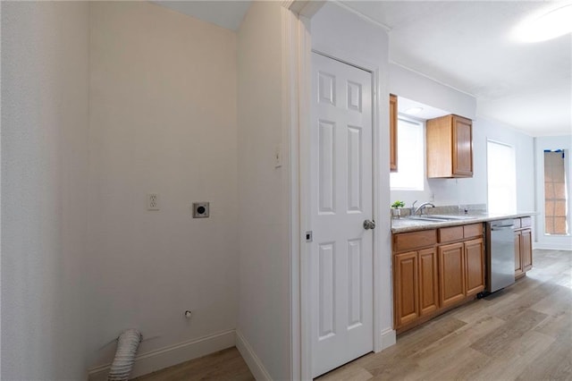 interior space featuring hookup for an electric dryer, light hardwood / wood-style floors, gas dryer hookup, and sink