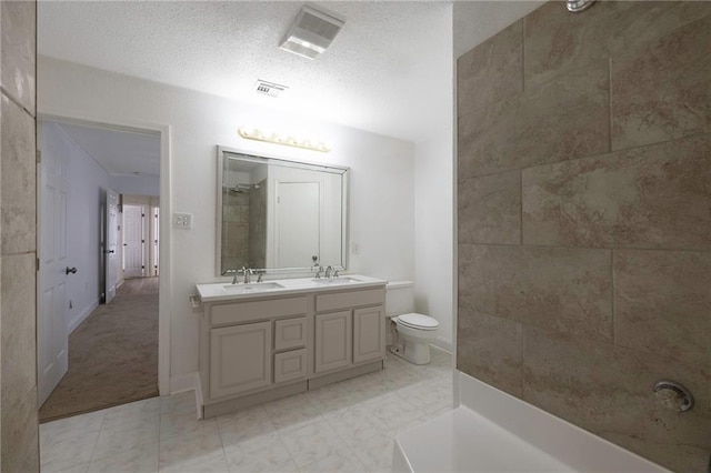 bathroom with a textured ceiling, vanity, toilet, and tile patterned floors