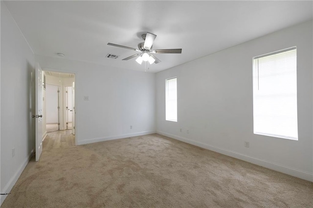 spare room with ceiling fan and light carpet