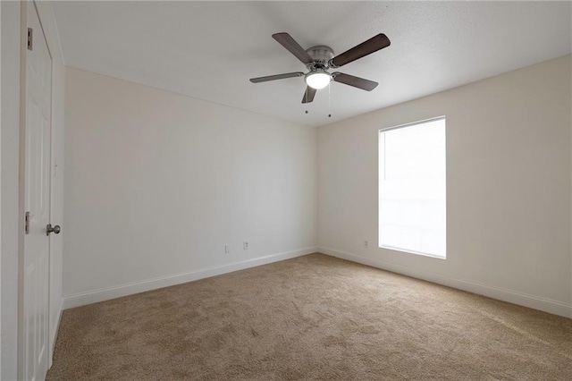 carpeted spare room with ceiling fan