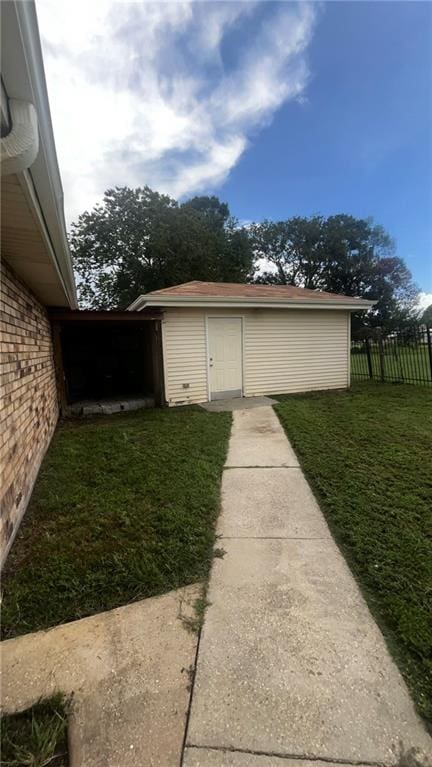 view of side of home featuring a yard and an outdoor structure