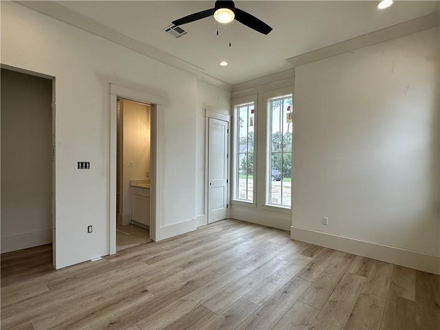 unfurnished bedroom with ceiling fan, light wood-type flooring, multiple windows, and ensuite bathroom