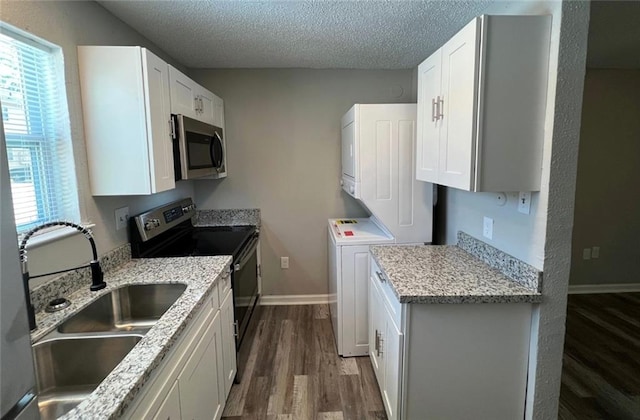 kitchen featuring sink, a textured ceiling, white cabinetry, stainless steel appliances, and dark hardwood / wood-style floors