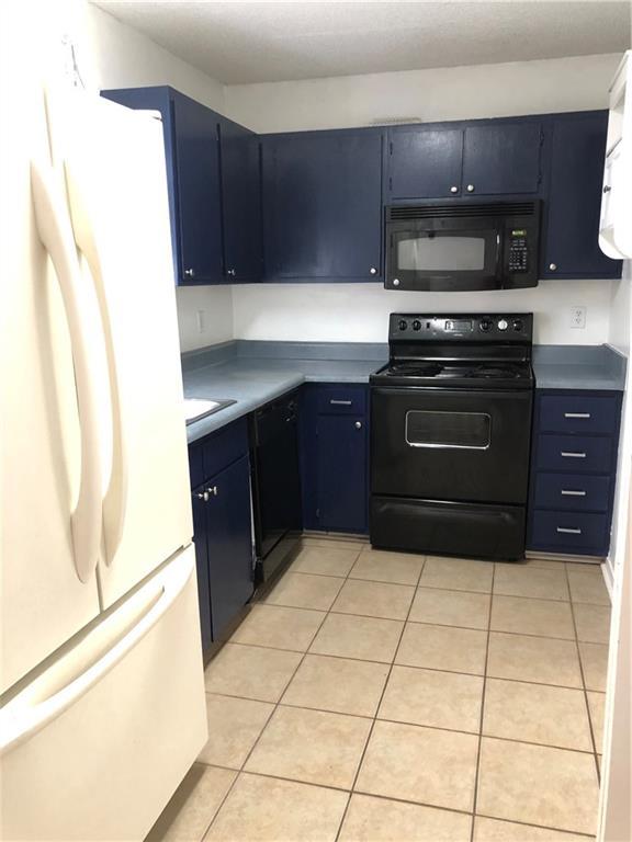 kitchen with blue cabinets, black appliances, and light tile patterned flooring