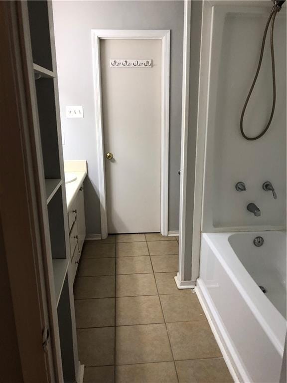 full bathroom with shower / bath combination, tile patterned flooring, vanity, and baseboards