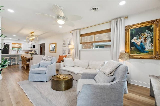 living room with a healthy amount of sunlight, ceiling fan, and light wood-type flooring