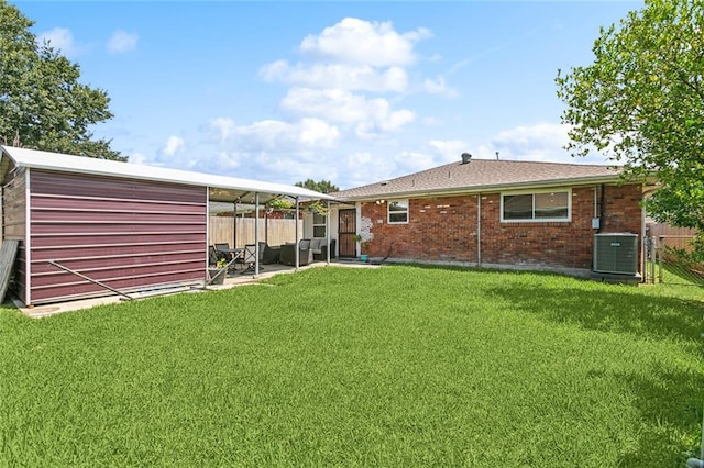 back of house featuring a storage unit, a lawn, and central air condition unit