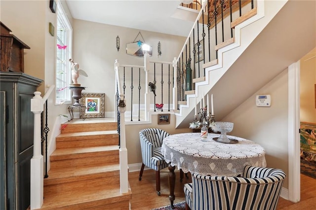 stairway featuring hardwood / wood-style flooring and a healthy amount of sunlight