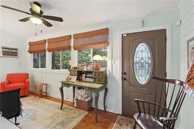 entrance foyer with a wall mounted AC, ceiling fan, wood-type flooring, and ornamental molding