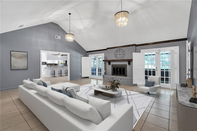 living room with ceiling fan with notable chandelier, a fireplace, light tile patterned floors, french doors, and high vaulted ceiling