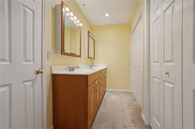 bathroom featuring double vanity, a sink, and baseboards