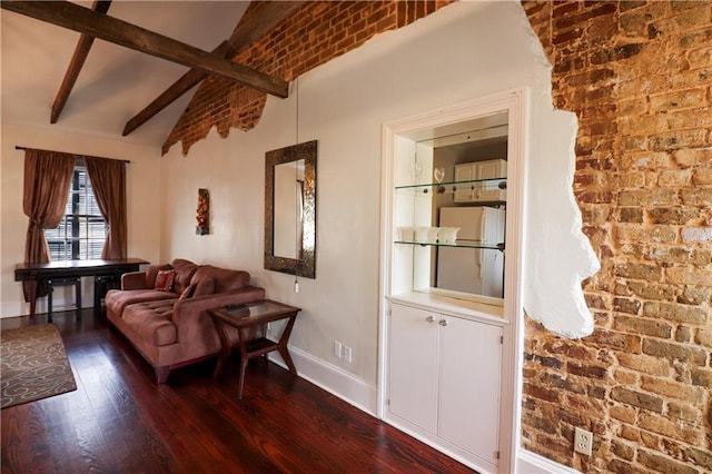 sitting room with vaulted ceiling with beams, hardwood / wood-style flooring, and brick wall