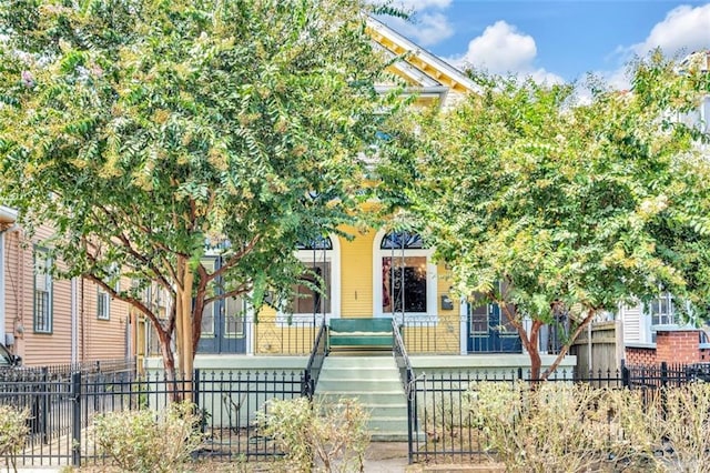 obstructed view of property featuring covered porch and a fenced front yard