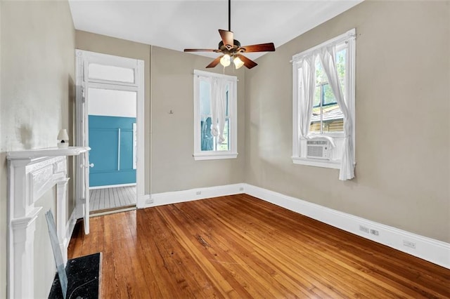 unfurnished living room featuring ceiling fan, wood-type flooring, cooling unit, and baseboards