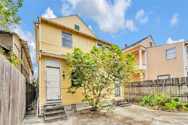 back of house featuring entry steps and a fenced backyard