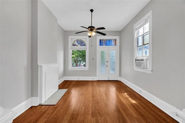 interior space with french doors, wood-type flooring, a ceiling fan, cooling unit, and baseboards