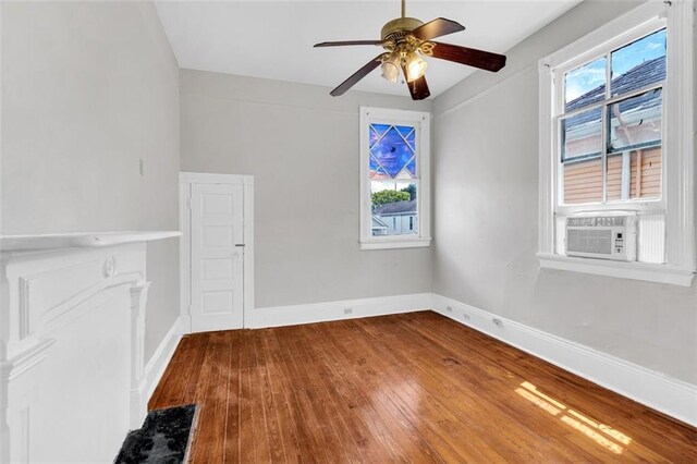 spare room with hardwood / wood-style floors, ceiling fan, baseboards, and cooling unit