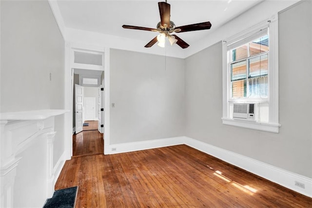 spare room featuring a ceiling fan, hardwood / wood-style flooring, and baseboards