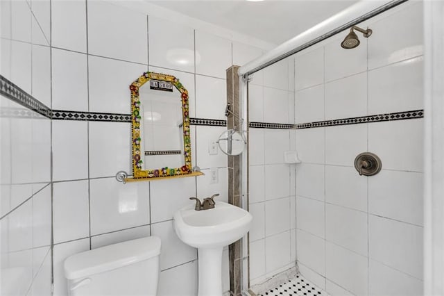 bathroom featuring toilet, a tile shower, and tile walls