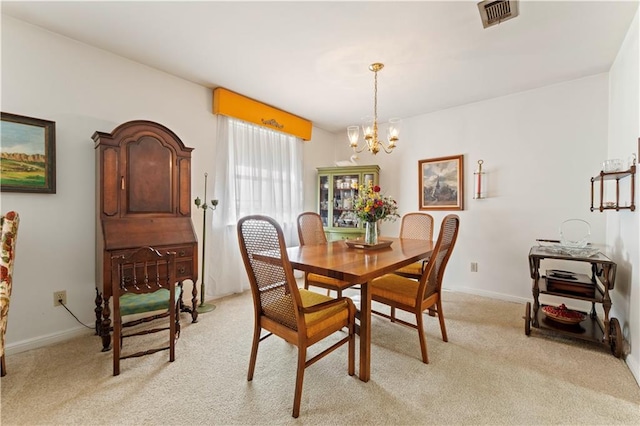 dining room featuring light carpet and an inviting chandelier