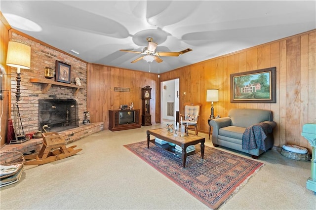 living room with ceiling fan, wooden walls, carpet, and a brick fireplace