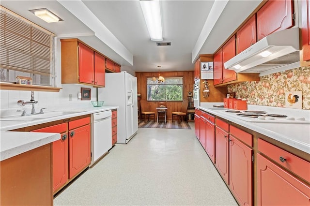 kitchen featuring white appliances, backsplash, an inviting chandelier, sink, and decorative light fixtures