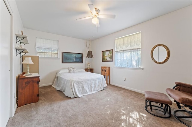 carpeted bedroom featuring multiple windows and ceiling fan