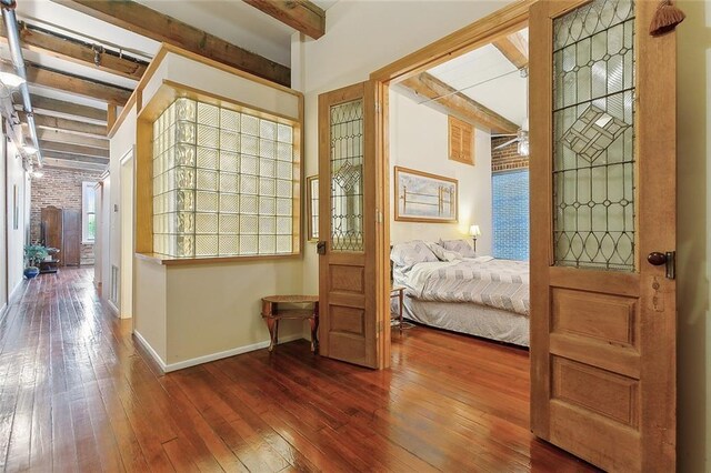 bedroom featuring beam ceiling and dark hardwood / wood-style floors