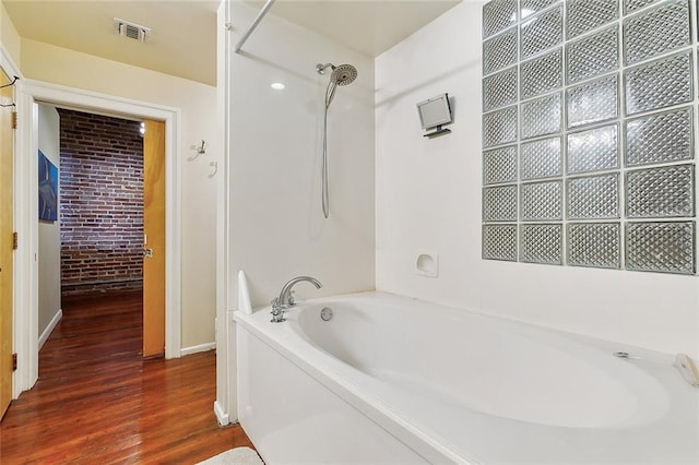 bathroom with hardwood / wood-style floors and shower with separate bathtub