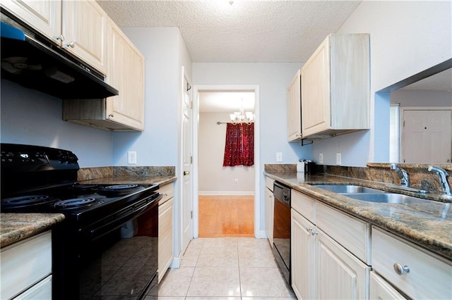 kitchen featuring a textured ceiling, light tile patterned flooring, under cabinet range hood, a sink, and black appliances