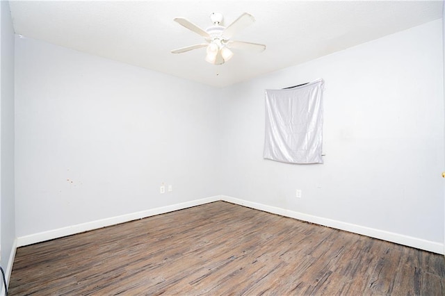 empty room with ceiling fan, wood finished floors, and baseboards