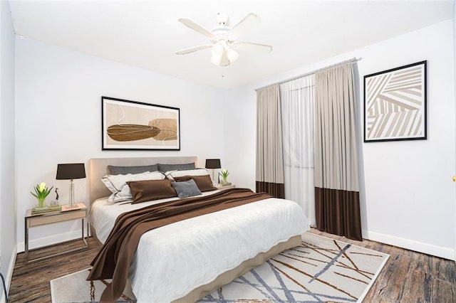 bedroom featuring a ceiling fan, baseboards, and wood finished floors