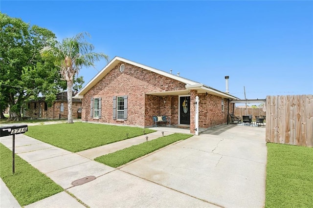 view of front of property featuring a patio and a front yard