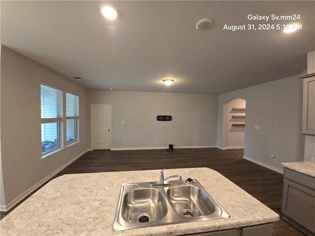 kitchen featuring an island with sink, sink, and dark hardwood / wood-style floors