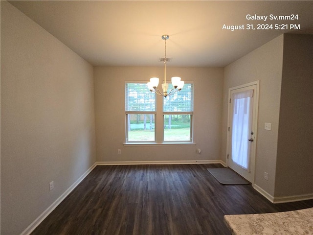 unfurnished dining area with dark hardwood / wood-style floors and a notable chandelier