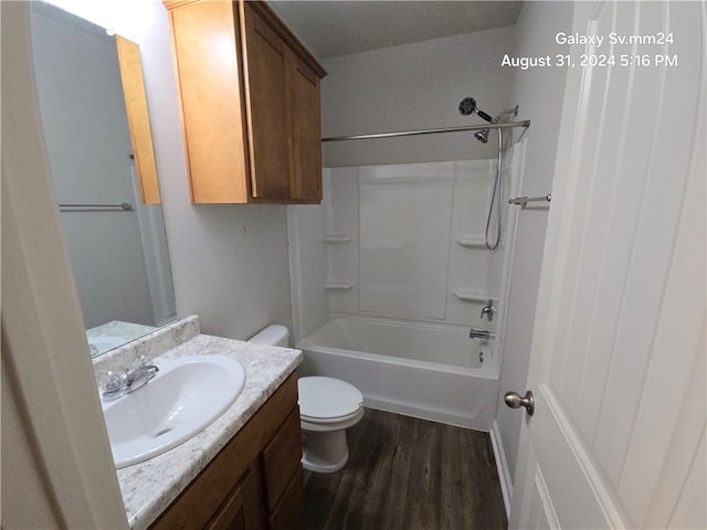 full bathroom with hardwood / wood-style floors, toilet, shower / washtub combination, and vanity