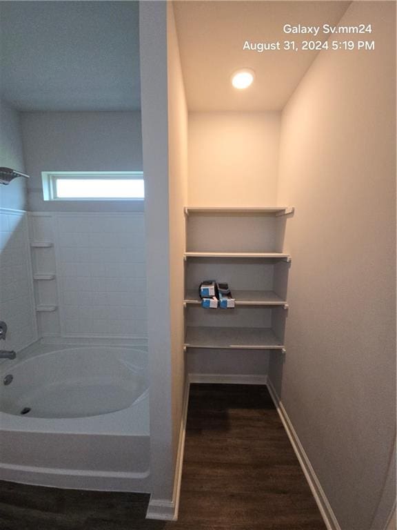 bathroom with hardwood / wood-style flooring and bathtub / shower combination