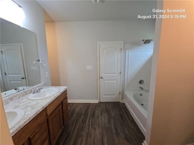 bathroom with vanity, tiled shower / bath, and hardwood / wood-style floors